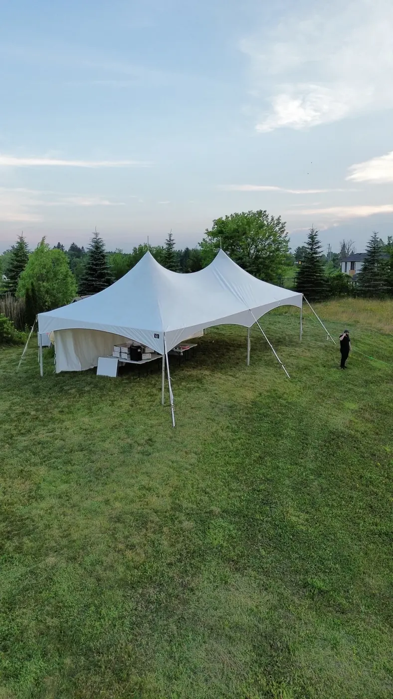 A white event tent prepared for an outdoor gathering