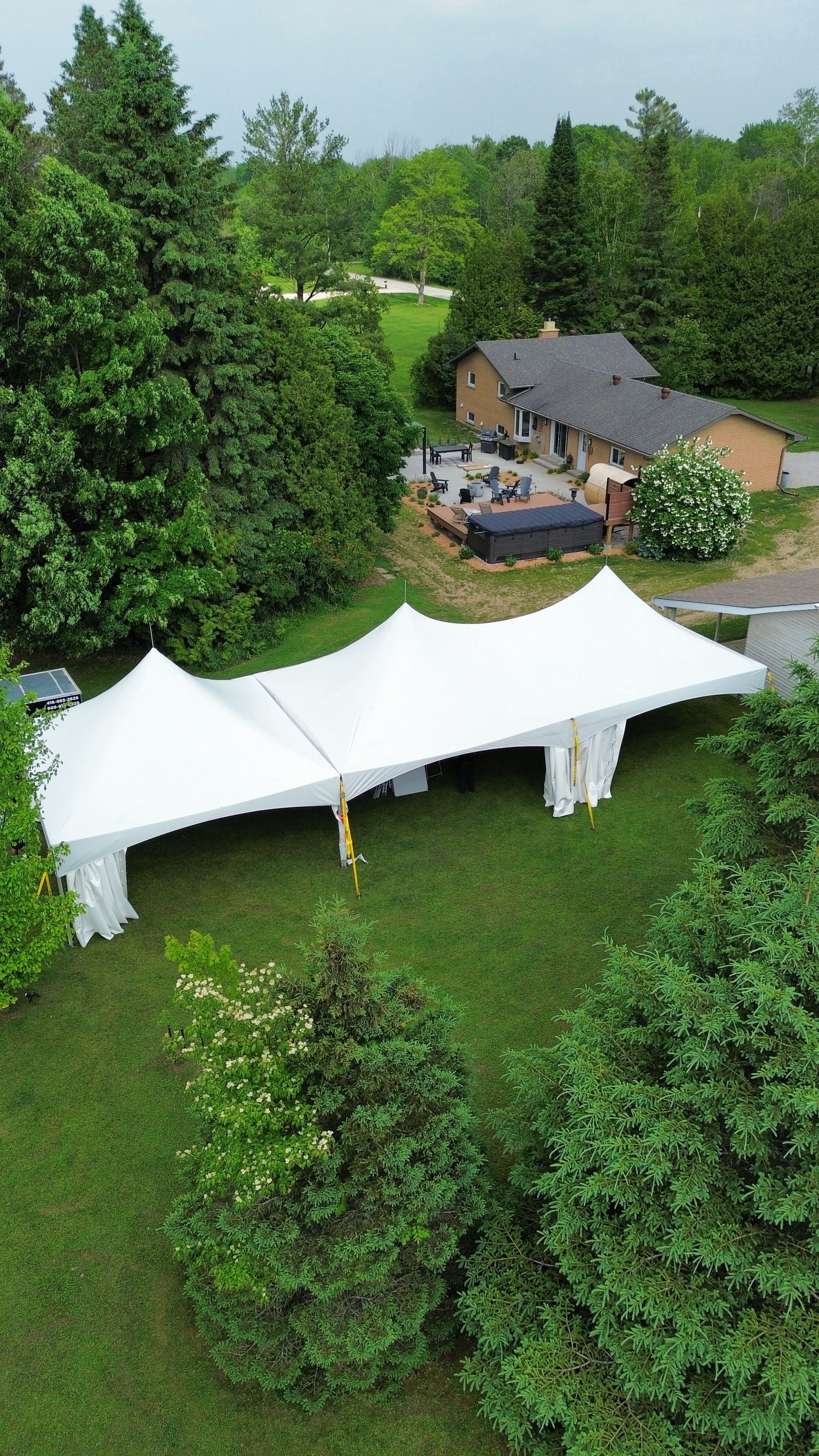 White tents covering a backyard lawn for a Dhillon Tents event