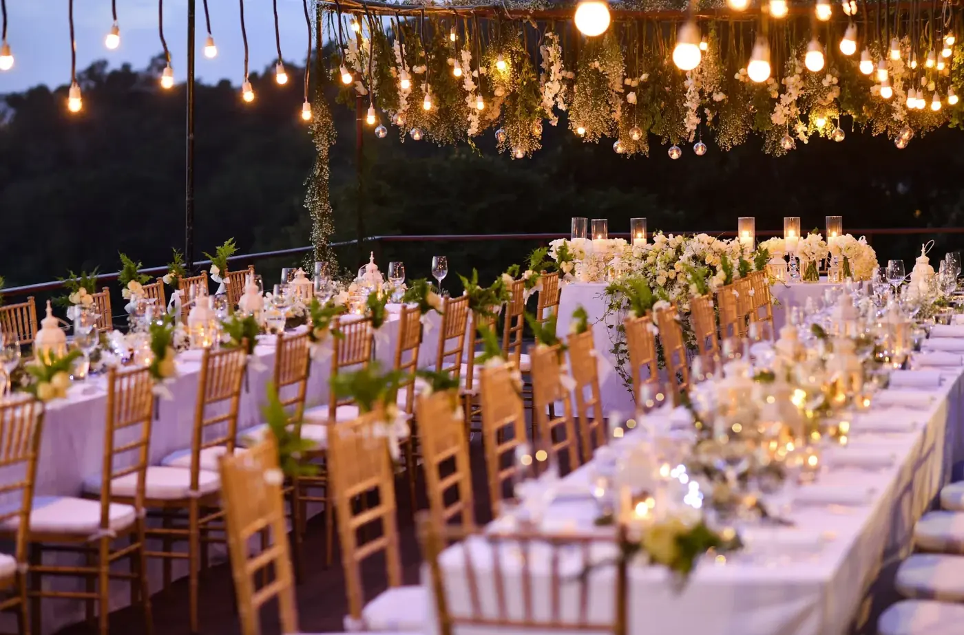 Rental tables and white chairs arranged for a catered outdoor gathering